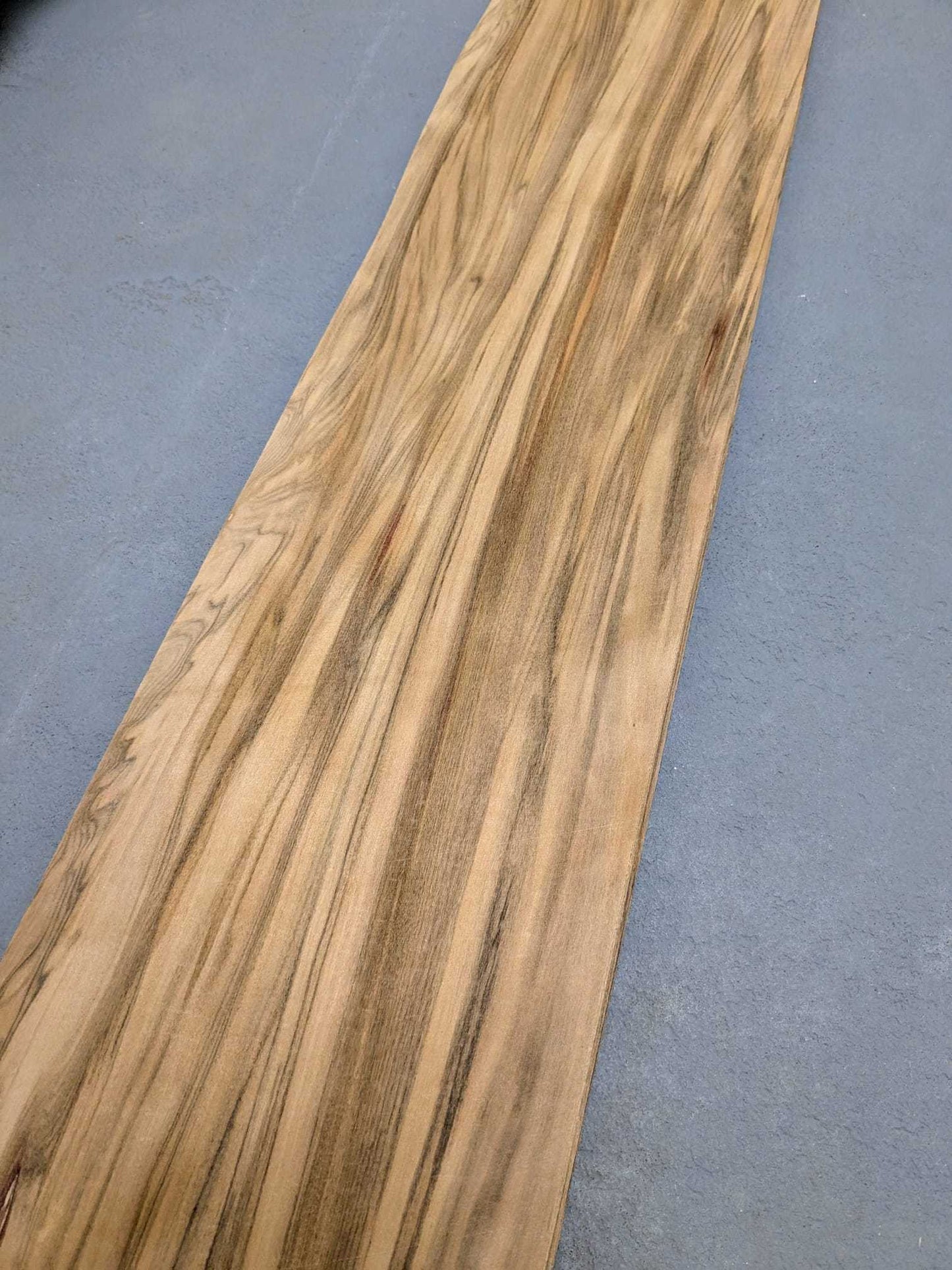 Detail van Red gum (satijnnoten) houtfineer met vloeiende nerfstructuur, los vel van 140x17 cm voor creatieve houtprojecten.